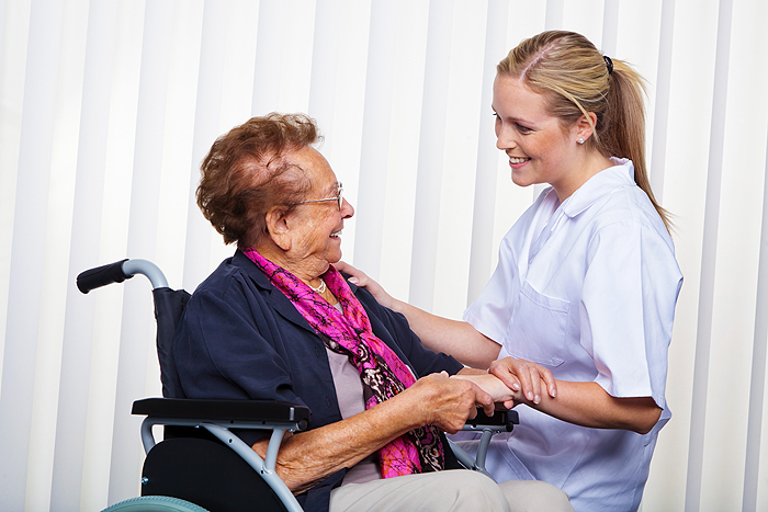 Caretaker helping elderly woman